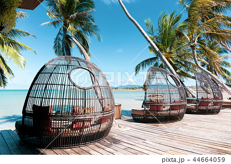 Rattan chair on wooden deck by the beach Rattan chair on wooden deck by the beach 44664059
