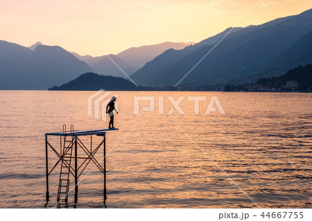 Silhouette of a woman trying to jump into water Silhouette of a woman trying to jump into water 44667755