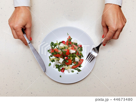 salad for visitor which holds knife and fork 44673480