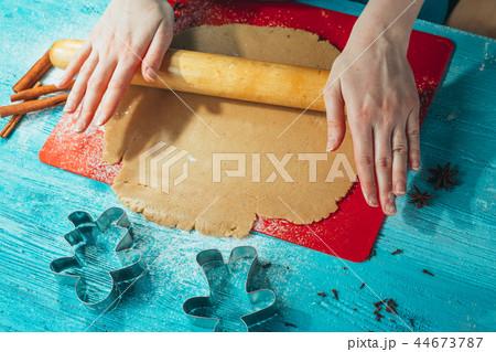 girl rolls the dough on the red board to table girl rolls the dough on the red board to table 44673787