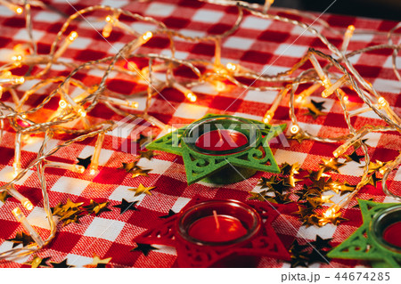 candle on red checkered tablecloths and garland candle on red checkered tablecloths and garland 44674285