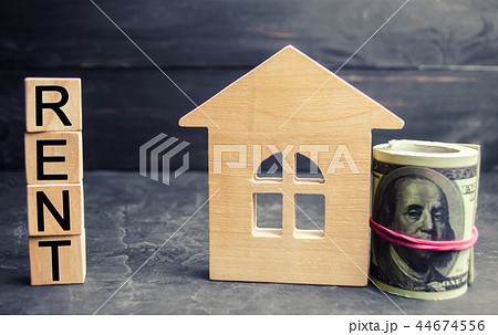 Dollars, wooden house and inscription "rent". 44674556