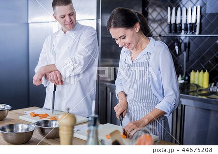 Smiling lady improving her skills in cooking 44675208
