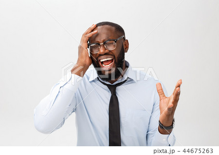 Portrait of desperate annoyed black male screaming in rage and anger tearing his hair out while Portrait of desperate annoyed black male screaming in rage and anger tearing his hair out while 44675263