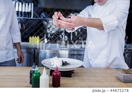 Talented cooks adding the last ingredient to a dish 44675278
