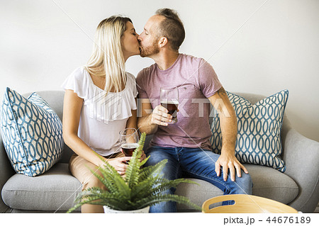 Relaxed young couple watching tv and drinking beer at home 44676189