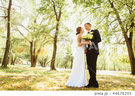 couple bride and groom on a park background couple bride and groom on a park background 44676205