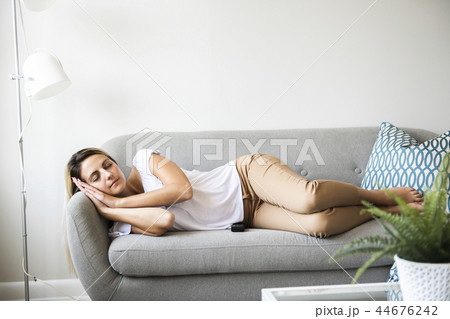 blond women sleep on the sofa at home 44676242