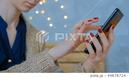 Woman using vertical black smartphone at home 44676724