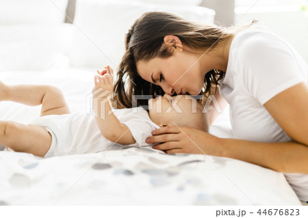 mother with baby on bed having good time mother with baby on bed having good time 44676823