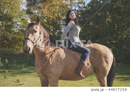 A Portrait of young beautiful woman with brown horse outdoors 44677259