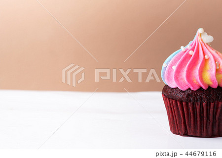 Cute little white heart on rainbow cream cupcake Cute little white heart on rainbow cream cupcake 44679116