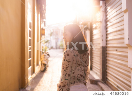 Woman walking on walkway in narrow of village 44680016