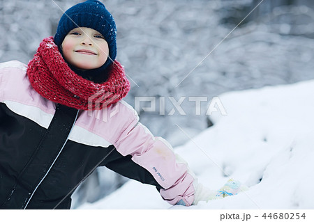 cheerful happy little girl on winter walk / little girl smiles and laughs in snow, plays winter for a walk. The concept of happy childhood. Warm sportswear down jacket, mittens, children's shoes cheerful happy little girl on winter walk / little girl smiles and laughs in snow, plays winter for a walk. The concept of happy childhood. Warm sportswear down jacket, mittens, children's shoes 44680254