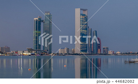 Abu Dhabi city skyline with skyscrapers before sunrise with water reflection night to day timelapse Abu Dhabi city skyline with skyscrapers before sunrise with water reflection night to day timelapse 44682002