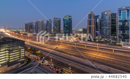 Aerial view of Jumeirah lakes towers skyscrapers day to night timelapse with traffic on sheikh zayed road. 44682540