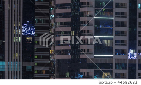 Windows of the multi-storey building of glass and steel lighting inside and moving people within timelapse Windows of the multi-storey building of glass and steel lighting inside and moving people within timelapse 44682633