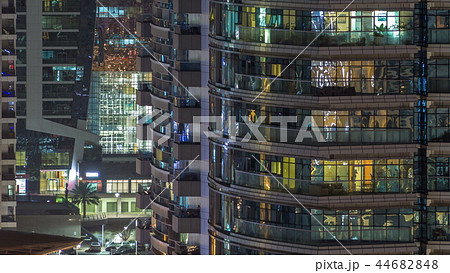 Windows of the multi-storey building of glass and steel lighting inside and moving people within timelapse Windows of the multi-storey building of glass and steel lighting inside and moving people within timelapse 44682848