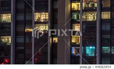 Windows of the multi-storey building of glass and steel lighting inside and moving people within timelapse Windows of the multi-storey building of glass and steel lighting inside and moving people within timelapse 44682854