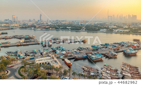 Dubai creek landscape timelapse with boats and ship in port and modern buildings in the background during sunset Dubai creek landscape timelapse with boats and ship in port and modern buildings in the background during sunset 44682962