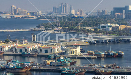 Dubai creek landscape timelapse with boats and ship in port and modern buildings in the background during sunset Dubai creek landscape timelapse with boats and ship in port and modern buildings in the background during sunset 44682992