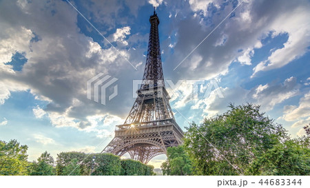 The Eiffel tower with warm rays of light in clouds during sunset timelapse hyperlapse. 44683344
