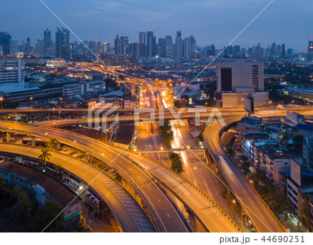 Cars driving on bridge roads shaped curve highways with skyscrap 44690251