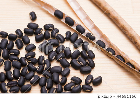 木のテーブルの上の黒小豆のさやと沢山の豆 木のテーブルの上の黒小豆のさやと沢山の豆 44691166