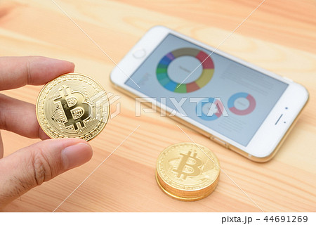 ビットコイン　仮想通貨イメージ　コインを持つ 44691269