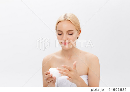 Close up beauty portrait of a laughing beautiful half naked woman applying face cream isolated over 44691685