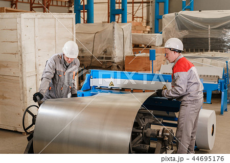 Production of ventilation and drainpipe. Workers adjusts the machine in the warehouse. the 44695176