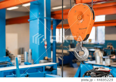Crane hook. The system of pulleys and ropes, a hanging mechanism in the production area. Movement Crane hook. The system of pulleys and ropes, a hanging mechanism in the production area. Movement 44695229