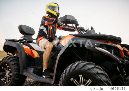 Rider in helmet on quad bike, front view, closeup 44696151