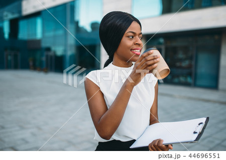 Business girl grinks coffee from cardboard cup Business girl grinks coffee from cardboard cup 44696551