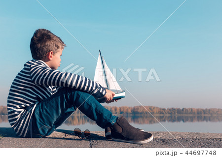 Child playing with sailing boat in beautiful light 44697748