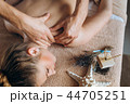 Close up of therapist doing neck massage on woman in spa against colorful green background. 44705251