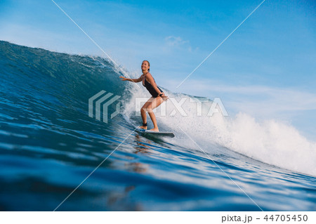Surfer girl on ocean wave. Woman in ocean 44705450