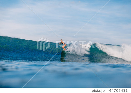 Professional surf girl at surfboard ride on barrel 44705451