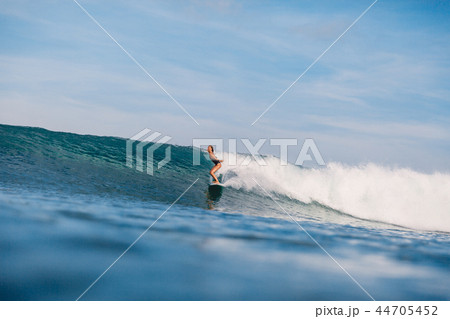Young surfer girl at surfboard on overhead wave. 44705452
