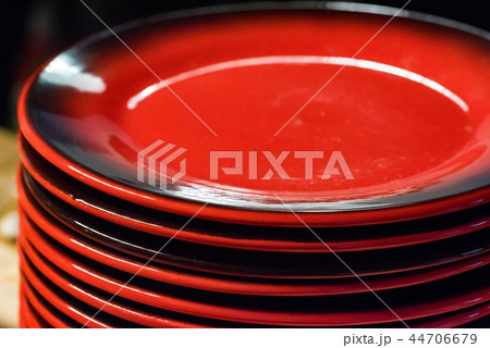 Stack of colorful red ceramics plates on dark background 44706679