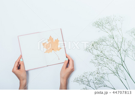 Girl holding open book with yellow autumn 44707813