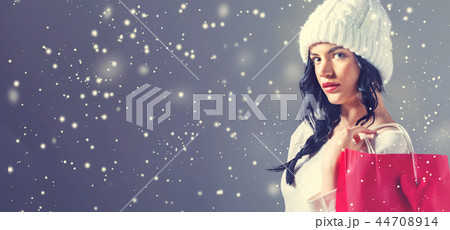Happy young woman holding a shopping bag Happy young woman holding a shopping bag 44708914