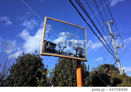 ミラーに反射した美しい雲と青い空、家と電柱、電信柱と電線。鏡と標識 44708996