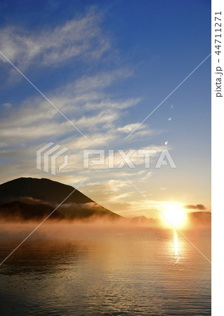 奥日光中禅寺湖千手ヶ浜の日の出 朝焼けに霧立つ湖面と男体山の写真素材