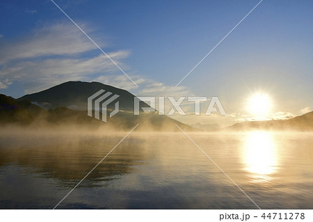 奥日光中禅寺湖千手ヶ浜の日の出 霧立つ湖面に男体山の写真素材