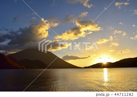 奥日光中禅寺湖千手ヶ浜の日の出 霧立つ湖面に男体山の写真素材