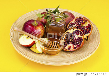 Rosh hashanah (jewish holiday) concept. Honey, apple and pomegranate on wooden dish 44716648