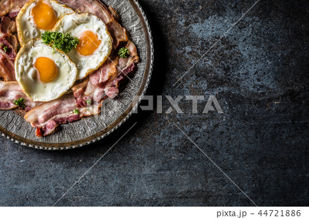 Top of view roasted bacon and egg with herbs. Top of view roasted bacon and egg with herbs. 44721886