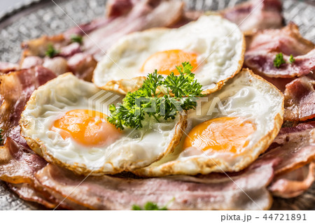 Close-up roasted bacon and egg with herbs. Close-up roasted bacon and egg with herbs. 44721891