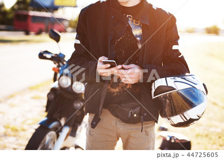Close up view of biker's hands using his smartphone 44725605